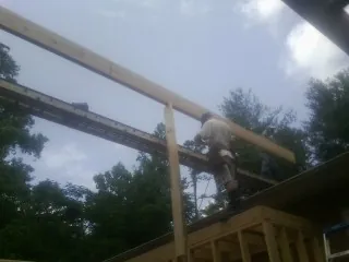 Carpenter setting a ridge beam over a new addition frame — Ice Dam Removal by Roofing Brothers in South Royalton