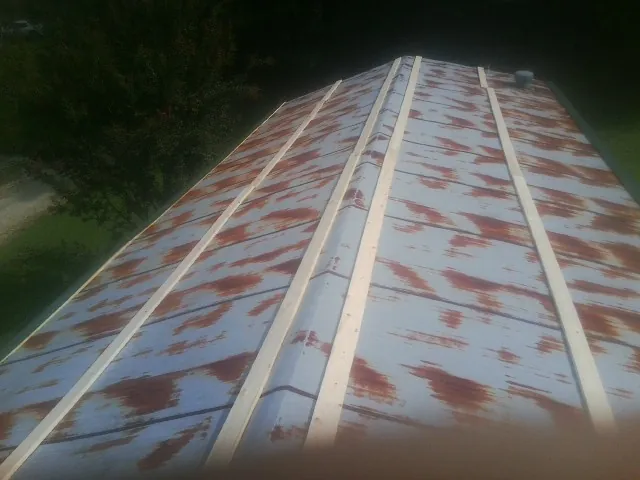 Rusted metal roof panels with new wood purlins before replacement — Storm Damage Roof Repair in South Royalton by Roofing Brothers