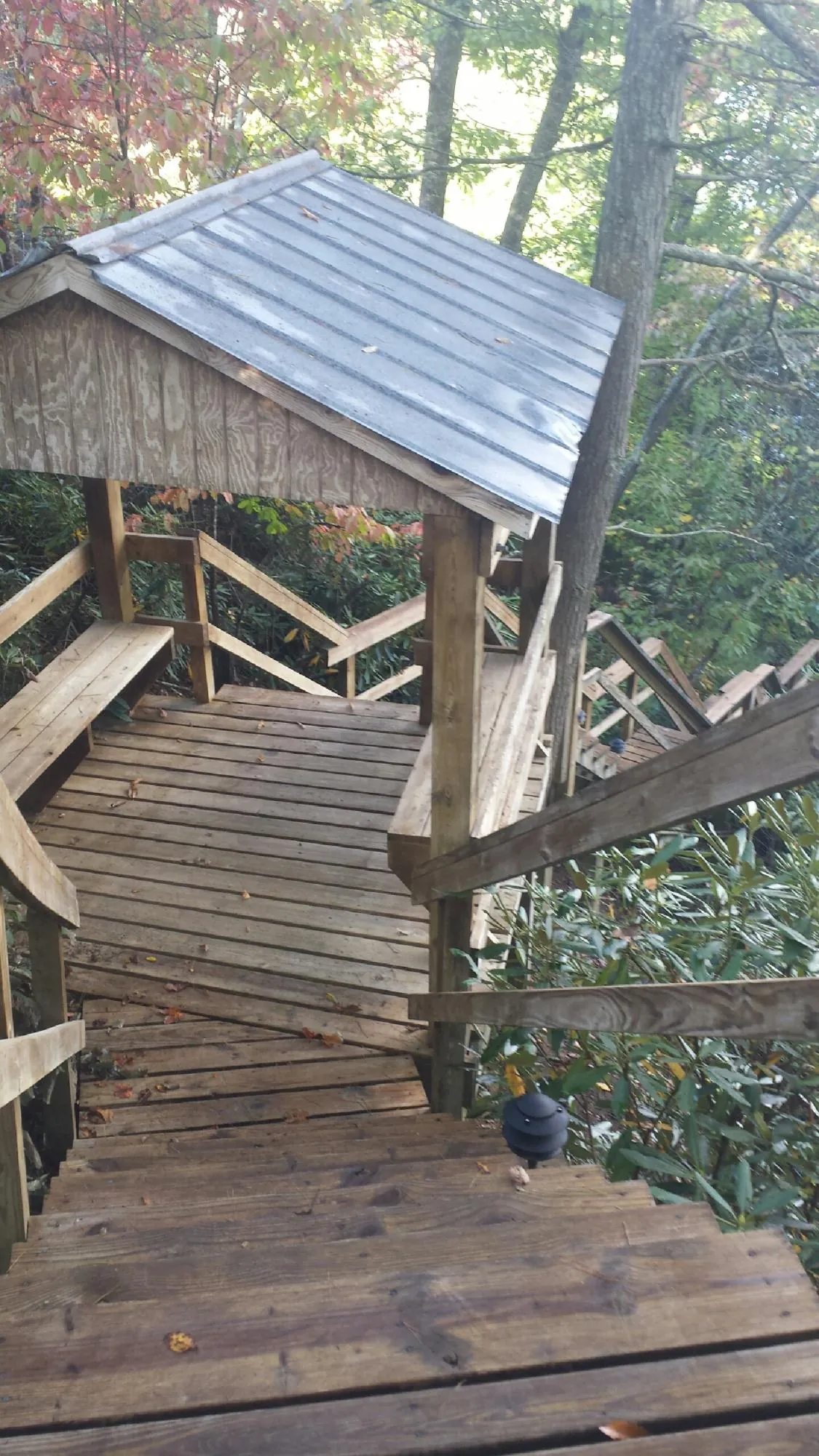 Metal roofed shelter over wooden steps on a wooded walkway — Skylight Repair & Installation work by our crew in South Royalton