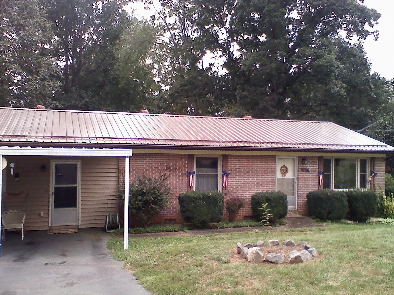 Bronze metal roof and carport on a brick ranch home — Roof Repair work by our crew in South Royalton